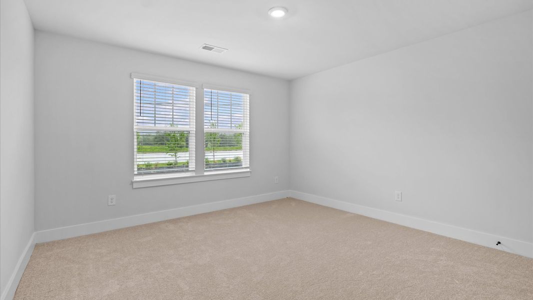 Inviting bedroom with tasteful finishes and large windows that create a fresh, open ambiance at Silo Ridge in Anderson, SC
