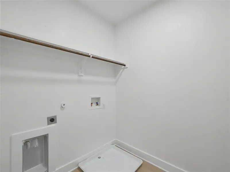 Utility space with wood-finish flooring and white baseboards