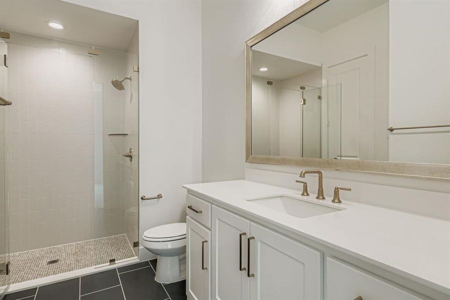 Bathroom featuring vanity, dark tile patterned flooring, a stall shower, and recessed lighting Bathroom featuring vanity, dark tile patterned flooring, a stall shower, and recessed lighting