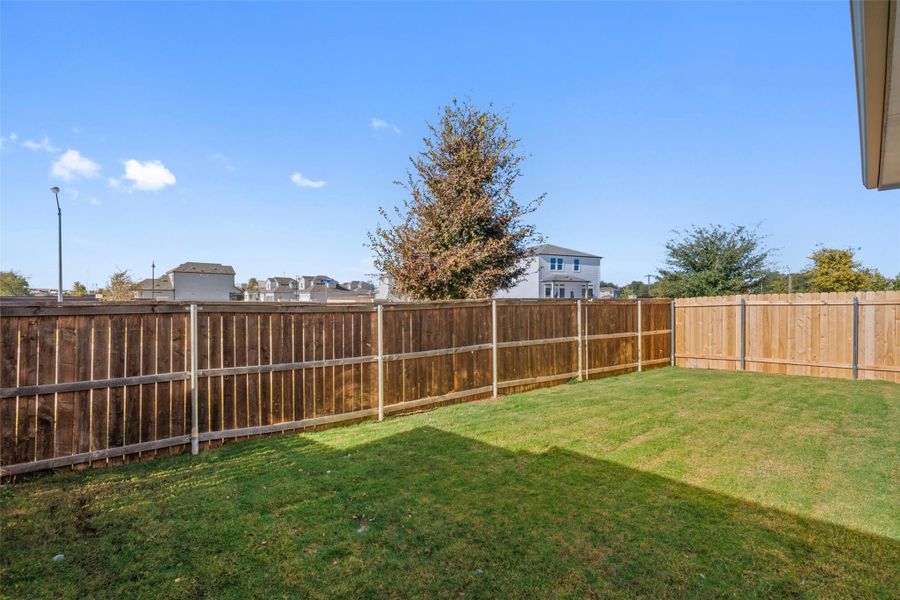 Fenced backyard with a residential view Fenced backyard with a residential view