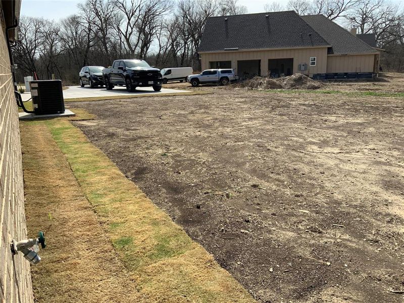 View of yard featuring driveway and a garage View of yard featuring driveway and a garage