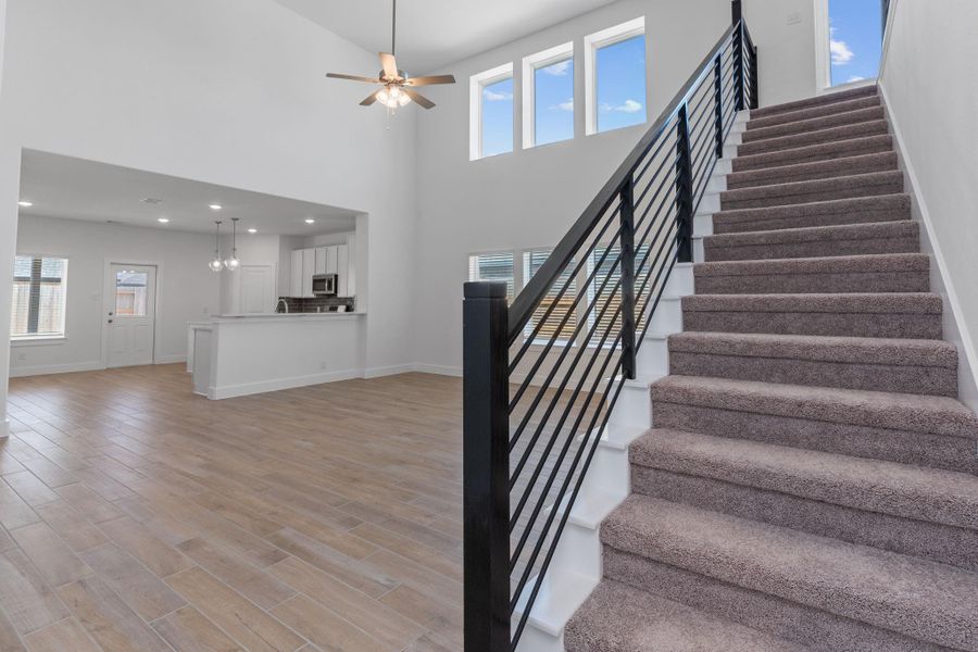 Talk about a showstopper! The dramatic two-story family room is complemented by soaring ceilings, expansive windows, and a sleek modern staircase that adds architectural flair. Talk about a showstopper! The dramatic two-story family room is complemented by soaring ceilings, expansive windows, and a sleek modern staircase that adds architectural flair.