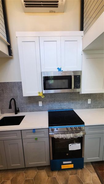 Kitchen featuring stainless GE 30" microwave/vent and 24" range. Kitchen featuring stainless GE 30" microwave/vent and 24" range.