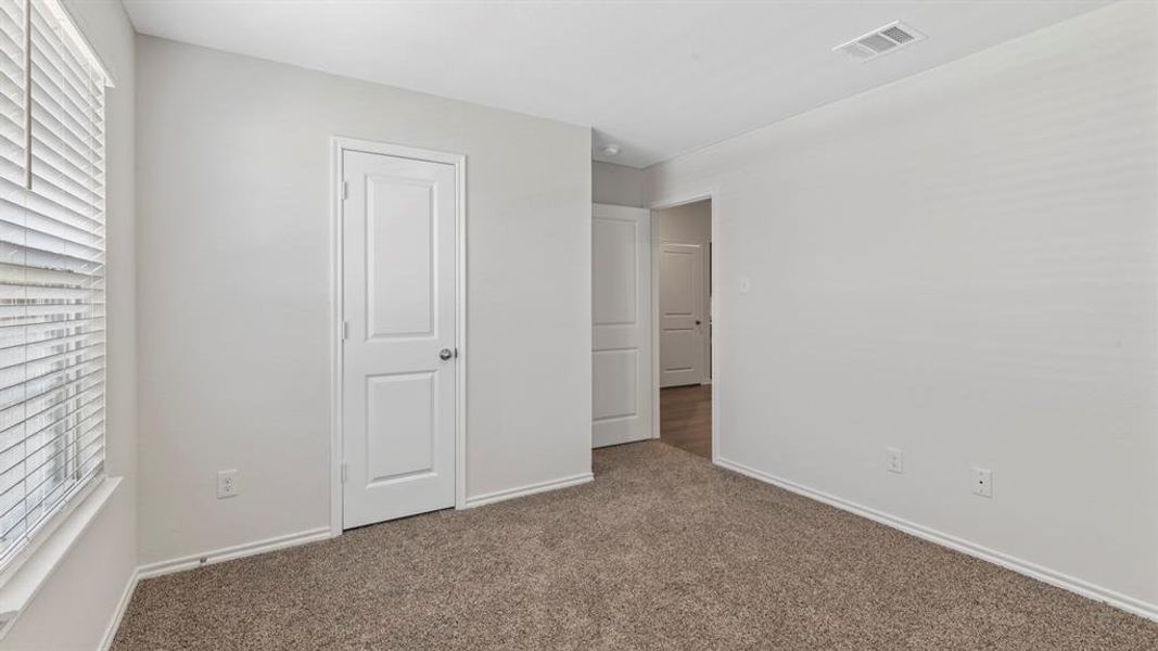 Unfurnished bedroom featuring multiple windows and carpet floors