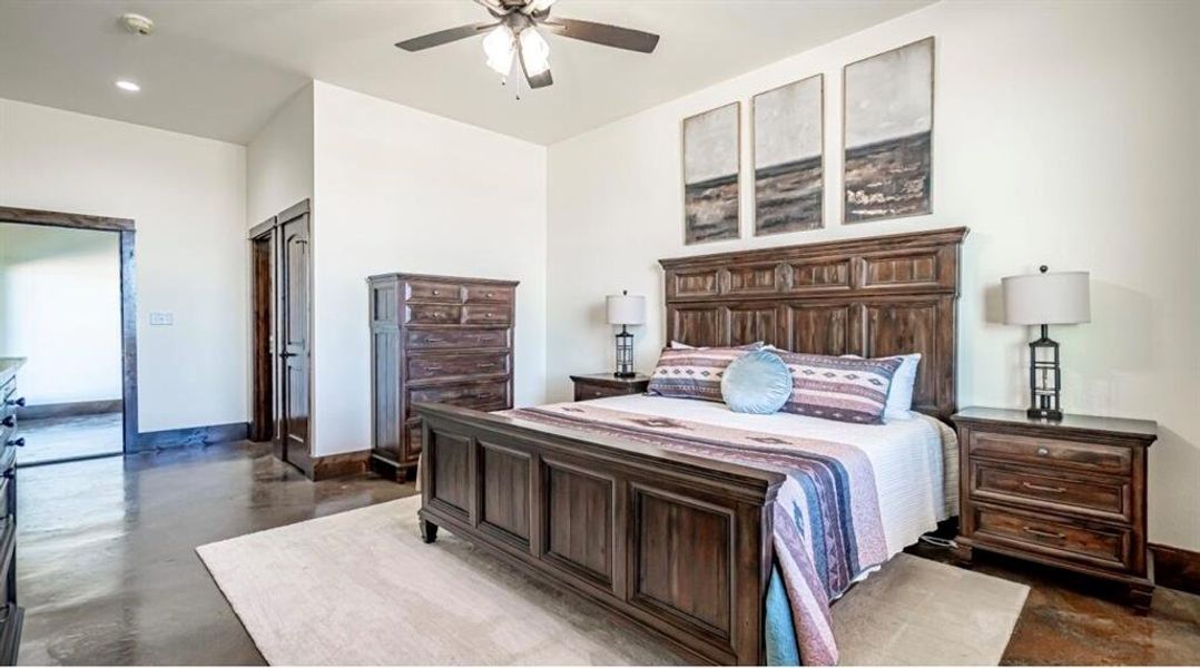 Bedroom featuring finished concrete flooring, baseboards, ceiling fan, and recessed lighting Bedroom featuring finished concrete flooring, baseboards, ceiling fan, and recessed lighting