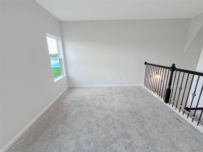 The Georgetown II- Upstairs Bonus Room/Game Room with Wrought Iron Railing. Home under construction. Sample floor plan photo used for illustrative purposes only. Upgrades, selections options, windows and colors may vary.