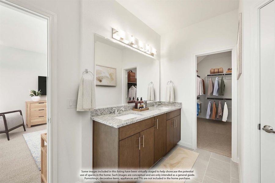Ensuite bathroom with wood vanity, granite countertop, large mirror, and walk-in closet visible through doorway