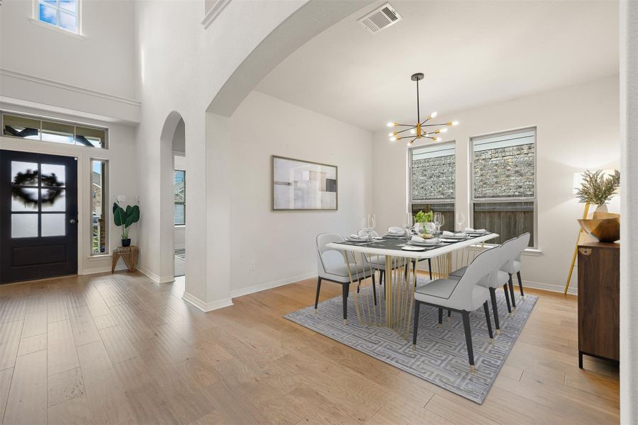 The formal dining room with updated Sputnik Chandelier brings in natural light from the front of the home and offers a dedicated space for meals and celebrations- Virtual Photo