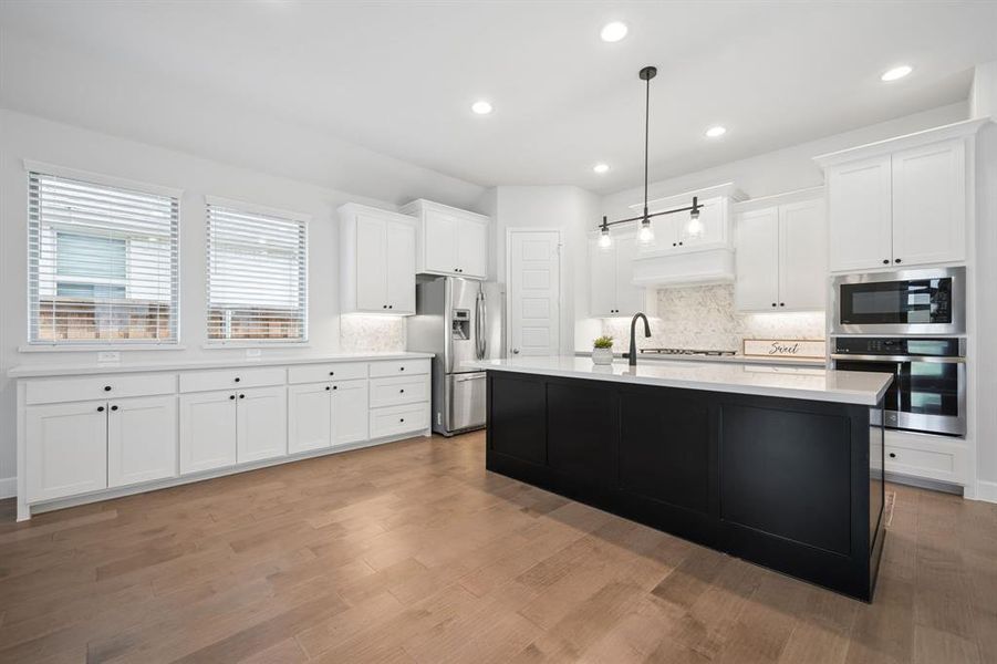 Modern kitchen featuring a contrasting black island with white quartz countertops