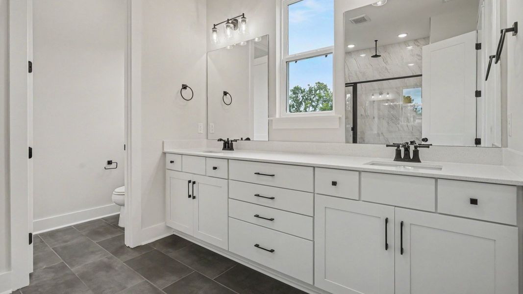 Primary bathroom with dual vanity and washroom