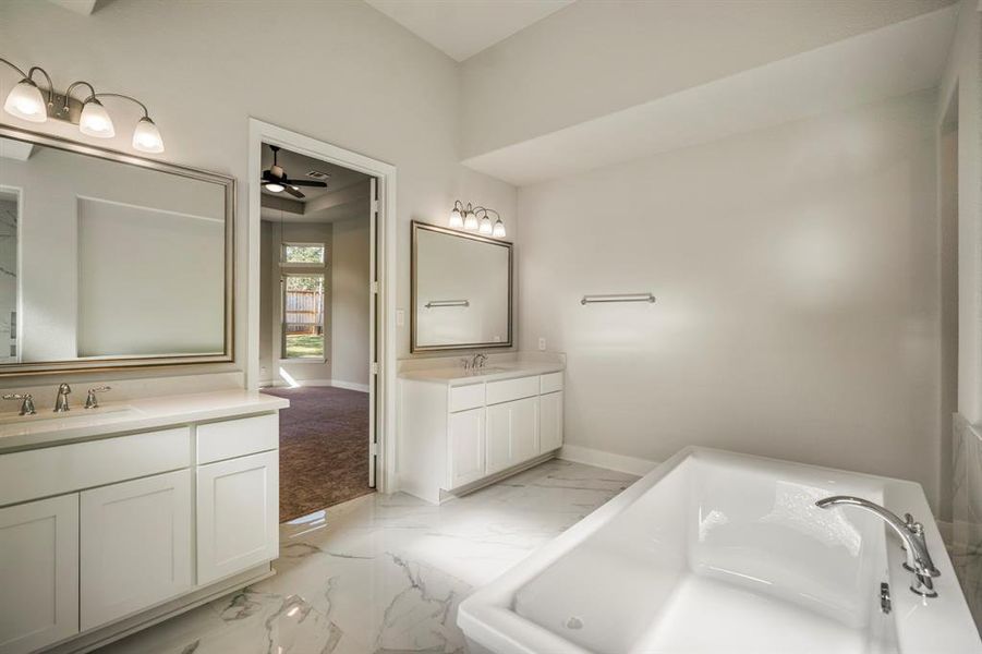 Dual vanities ensure plenty of space for morning routines, while soft natural light flows through privacy windows, creating a serene and refreshing atmosphere perfect for unwinding.