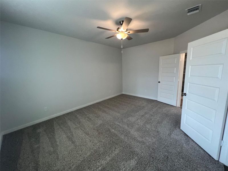 A quiet retreat with plush carpet flooring and a comforting ceiling fan awaits your personal touch.