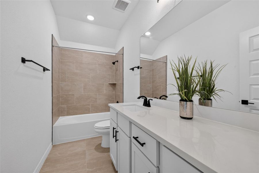 Tiled flooring and a modern vanity define this pristine secondary bath. Tiled flooring and a modern vanity define this pristine secondary bath.