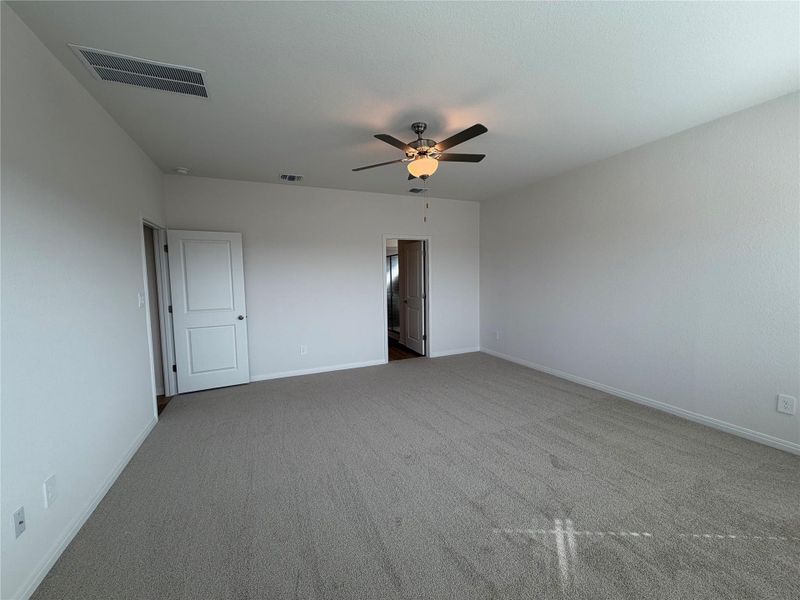 Unfurnished bedroom featuring light colored carpet and ceiling fan