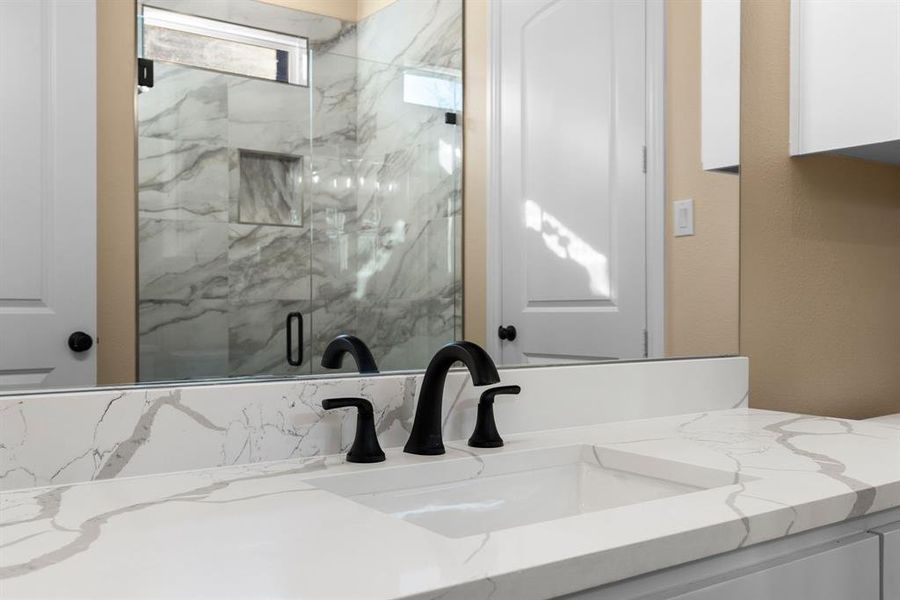 Bathroom with vanity and a shower with door