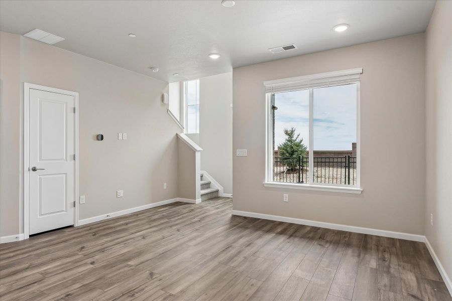 A room with a wood floor and a wood floor with a window.