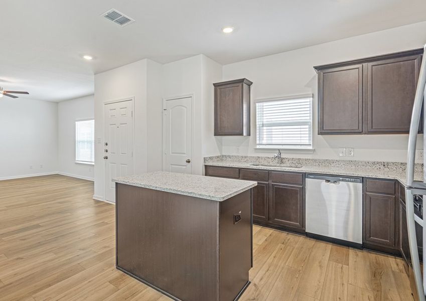 Upgraded kitchen with an island and granite countertops. Upgraded kitchen with an island and granite countertops.