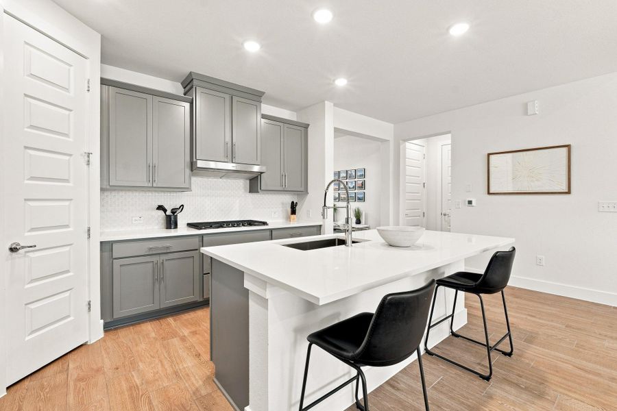 Perimeter kitchen view showing Dakota Maple North Sea painted cabinetry, shaker crown molding, and built-in Whirlpool oven with Air Fry. Perimeter kitchen view showing Dakota Maple North Sea painted cabinetry, shaker crown molding, and built-in Whirlpool oven with Air Fry.