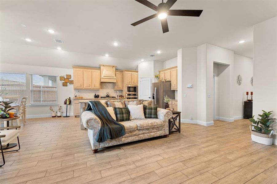 Living area featuring recessed lighting, ceiling fan, and light wood-style floors Living area featuring recessed lighting, ceiling fan, and light wood-style floors
