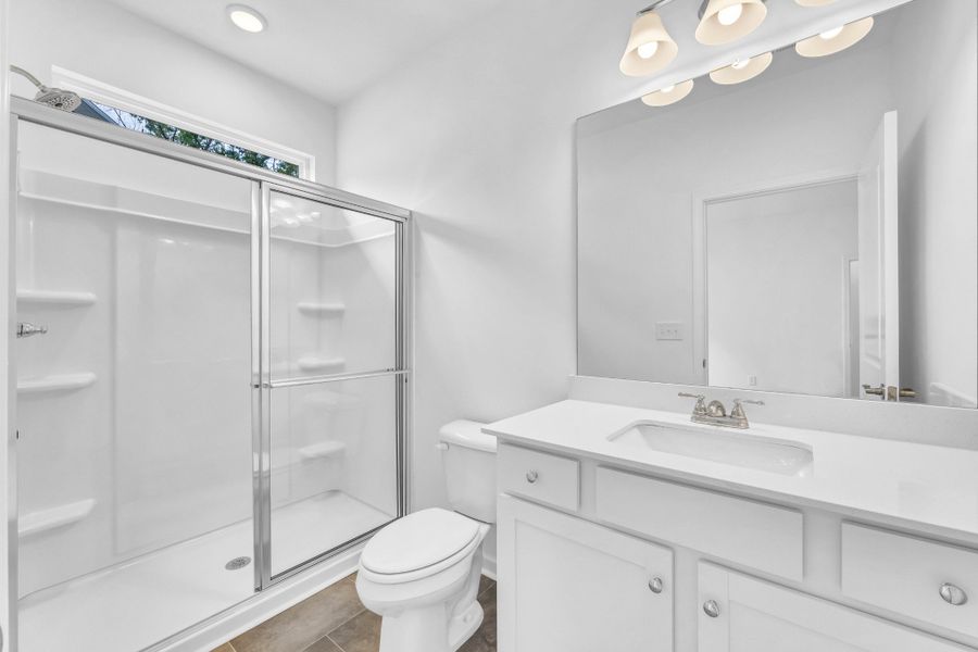 Primary bath includes shelved prefab shower and privacy window.