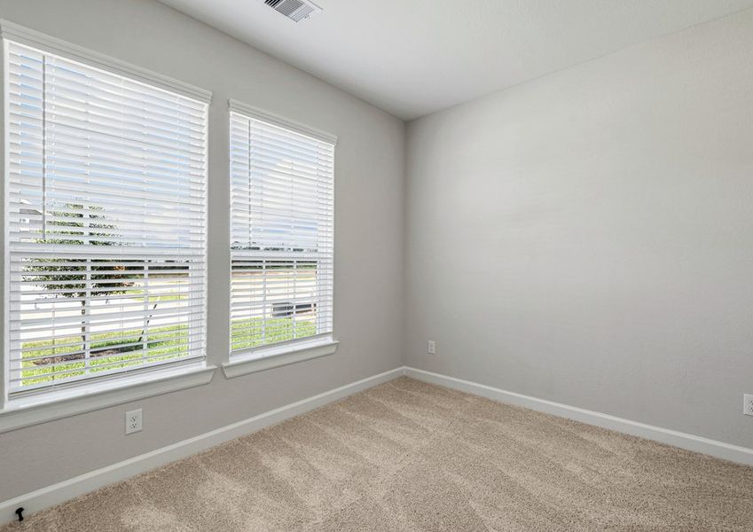 Two large windows fill the third bedroom with natural light