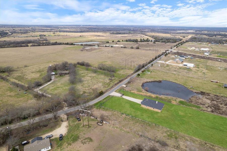 Birds eye view of property with a rural view and a water view