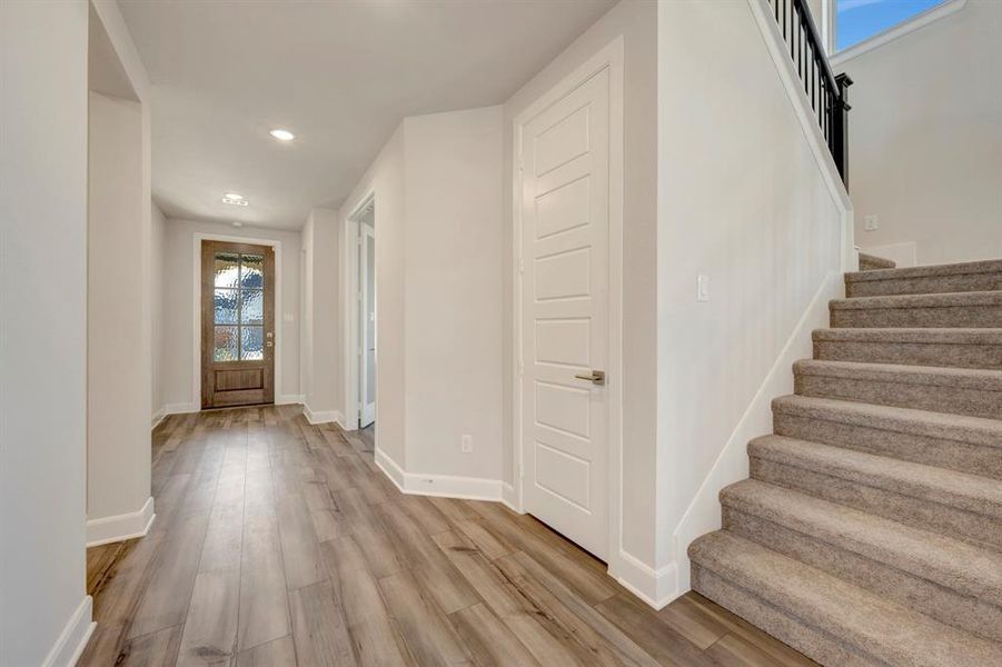 Entryway with light wood-type flooring and recessed lighting