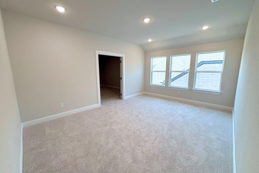 Spacious room featuring neutral carpeting, a trio of windows, recessed ceiling lighting, a neutral wall color, and white baseboards
