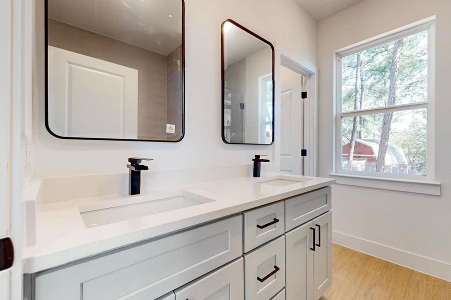 Bathroom featuring double vanity and light wood finished floors