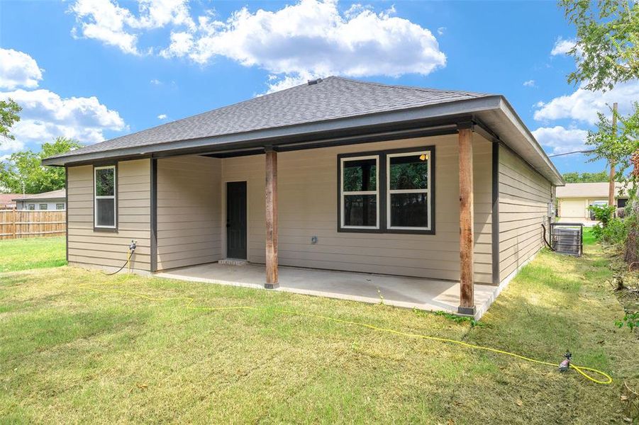 Back of property featuring a patio, central AC, and a yard