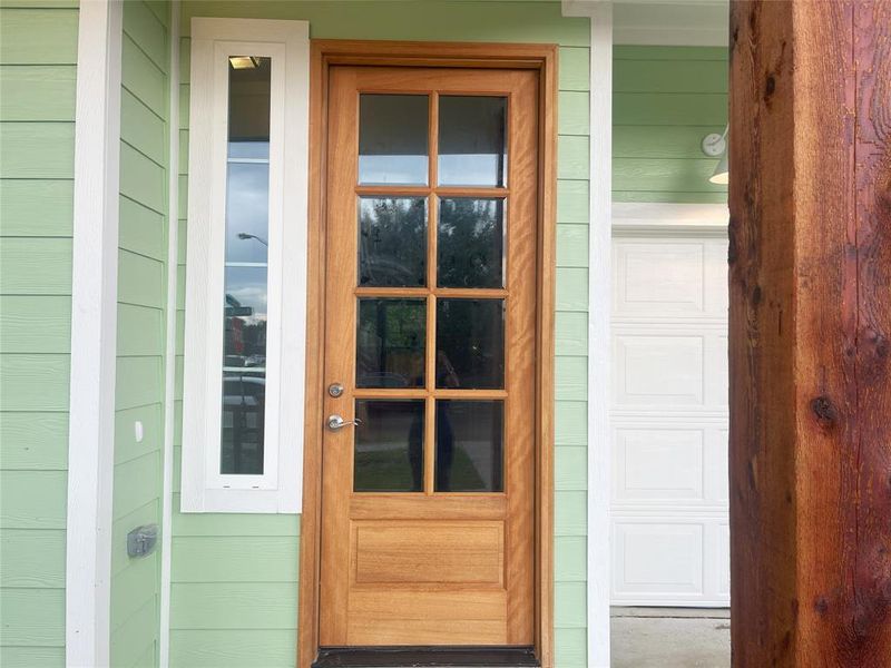 Doorway to property featuring covered porch and a garage