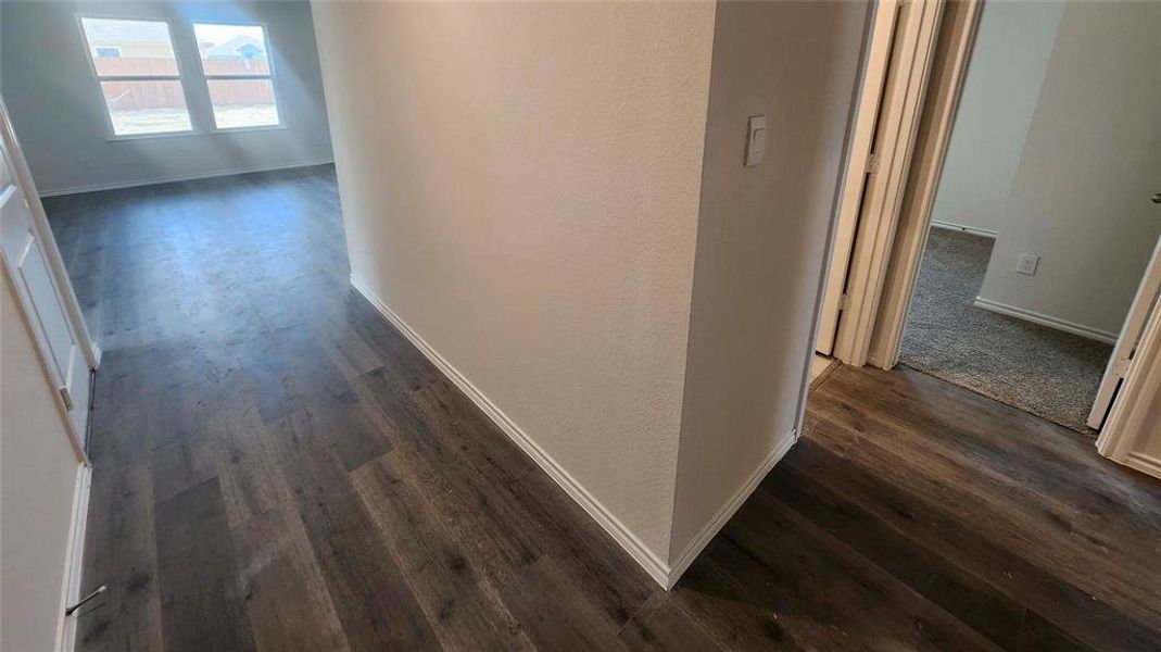 Wood-finish flooring throughout, featuring light grey wall paint and white baseboards