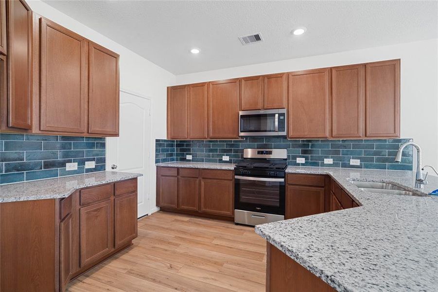 This kitchen is by far any chef’s dream! This spacious kitchen features high ceilings, stained wood cabinets, granite countertops, SS appliances, modern tile backsplash, recessed lighting, extended counter space, space for breakfast bar and a walk-in pantry all overlooking your huge family room.