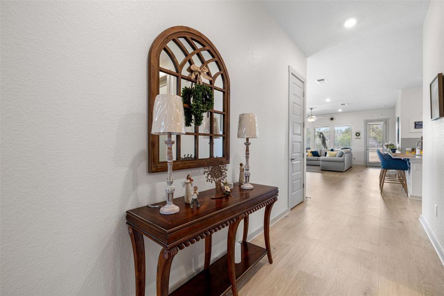 Hall with light wood-style floors, recessed lighting, and a textured wall Hall with light wood-style floors, recessed lighting, and a textured wall