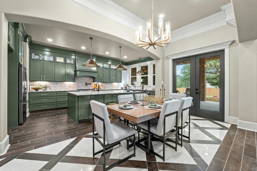 Kitchen and dining area featuring green cabinetry, a central island, and white brick-style backsplash