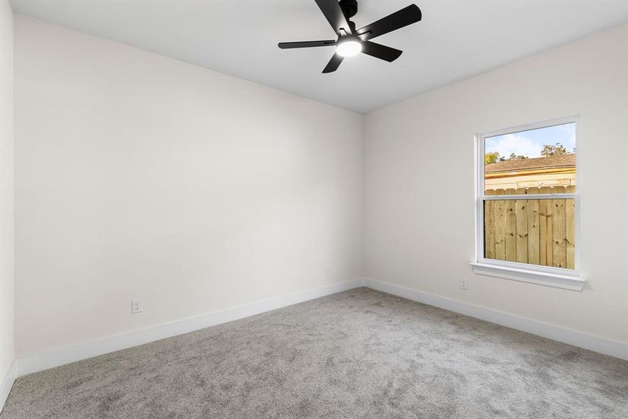 Empty room featuring carpet flooring and ceiling fan