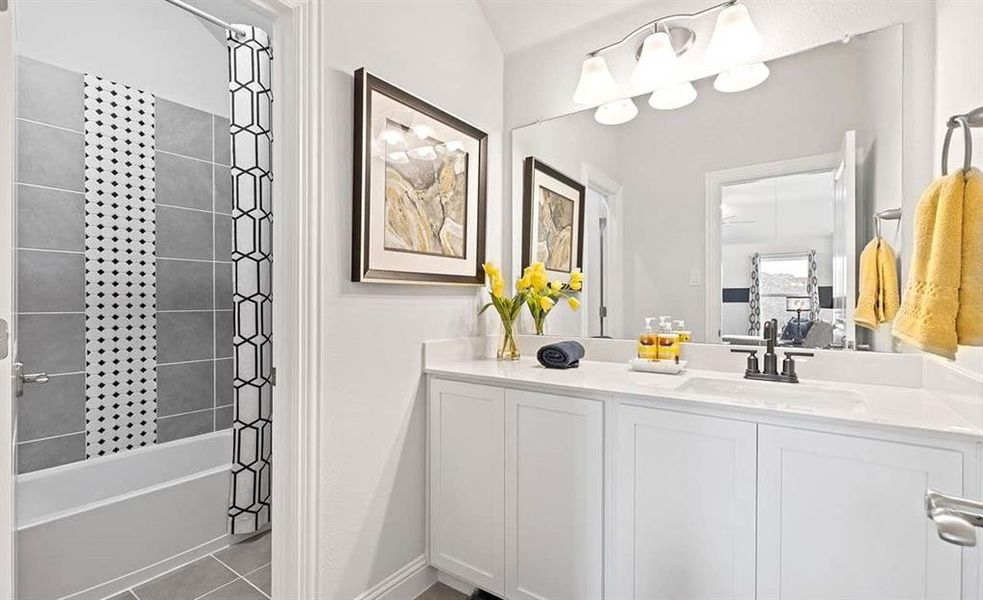 Bathroom featuring tiled shower / bath, tile flooring, and vanity