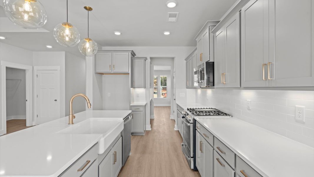 Top-notch kitchen featuring pendant lighting over a statement 7-foot island with seating
