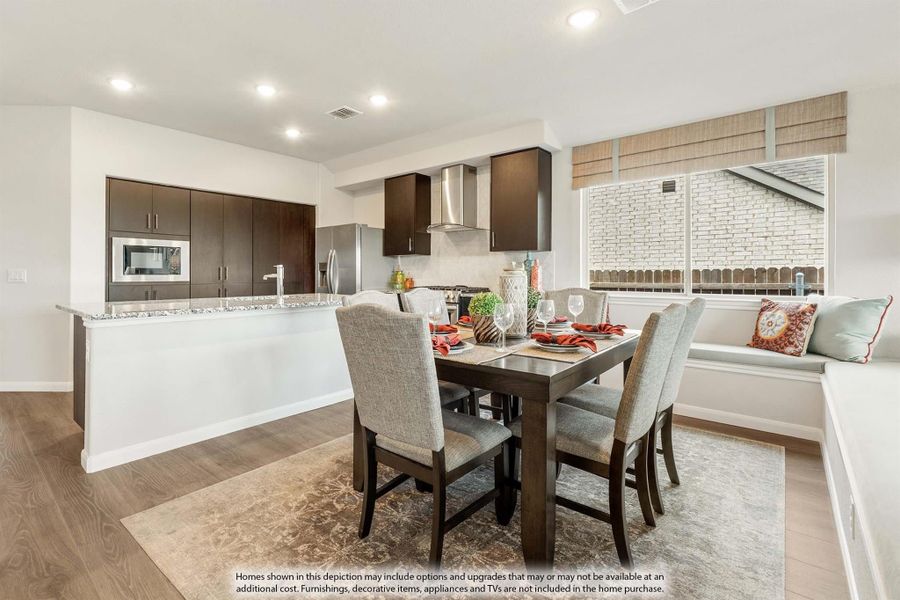 Open-plan dining area with dark wood table and chairs, adjacent to kitchen with dark cabinets and granite island Open-plan dining area with dark wood table and chairs, adjacent to kitchen with dark cabinets and granite island