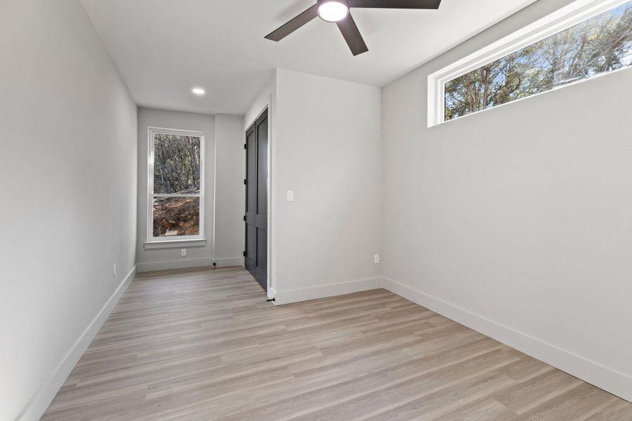 Unfurnished room with plenty of natural light, light wood-style flooring, and baseboards