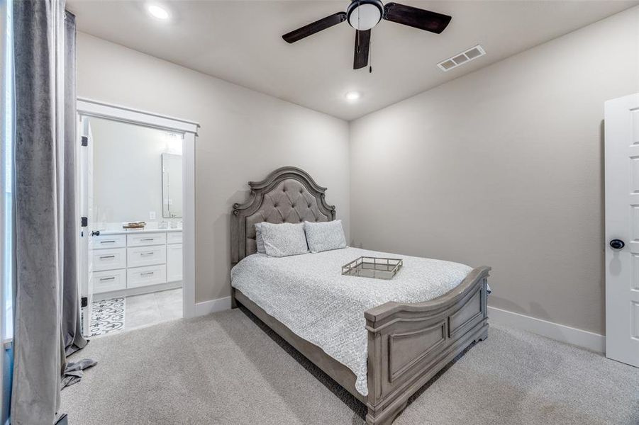 Bedroom with ensuite bath, light carpet, a ceiling fan, and recessed lighting