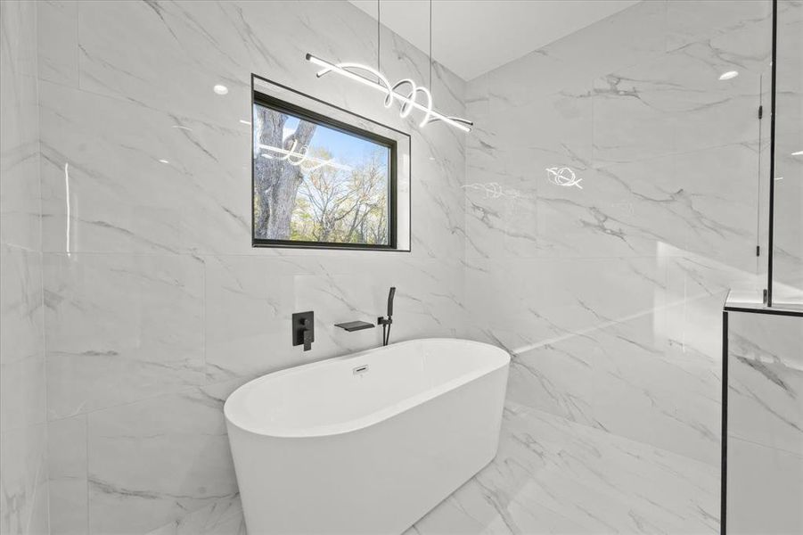 Bathroom featuring tile walls and a tub