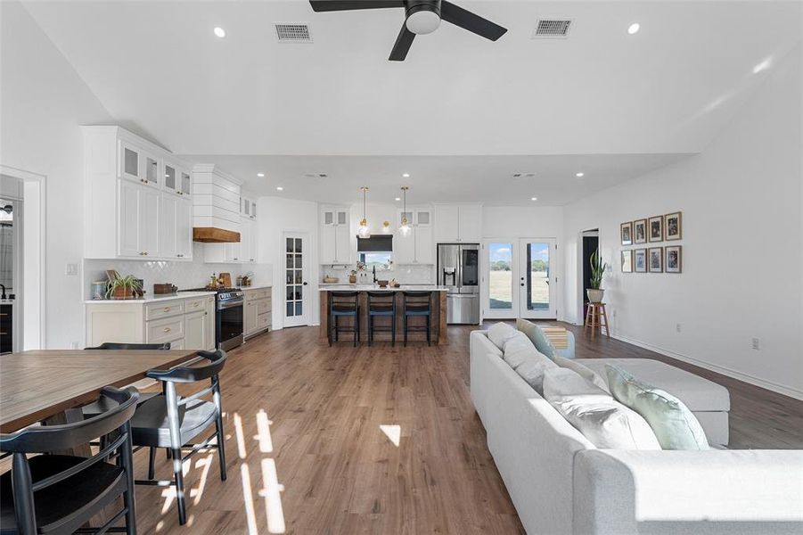 Living room with light wood finished floors, recessed lighting, and a ceiling fan