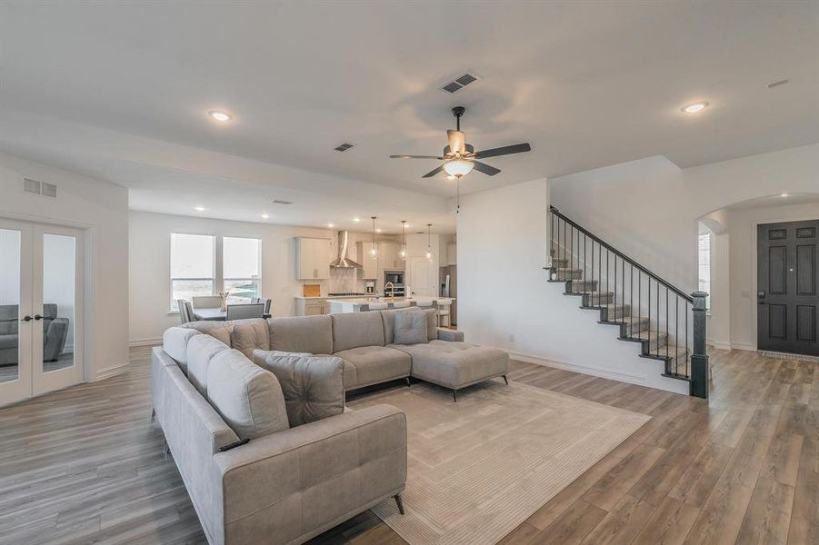 Living room featuring french doors, light hardwood / wood-style flooring, and ceiling fan