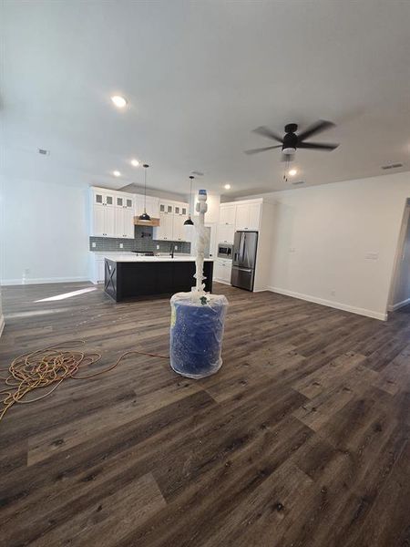 Living area with dark wood-style floors, a ceiling fan, and recessed lighting