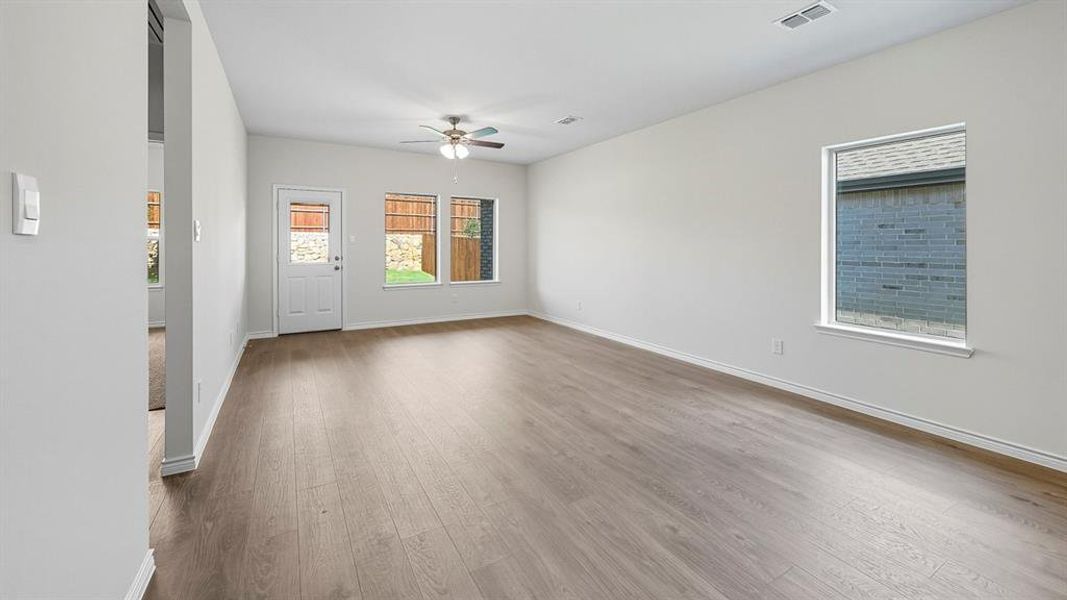 Empty room with light wood-style floors and a ceiling fan