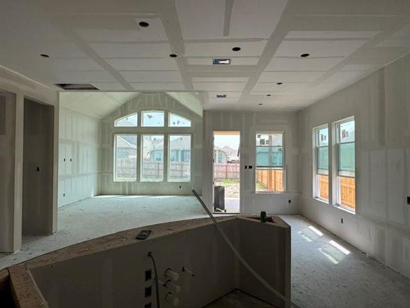 A promising interior under construction, featuring a coffered ceiling and numerous windows that invite natural light.