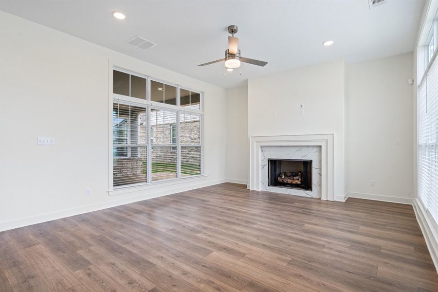 Unfurnished living room with ceiling fan, dark wood-style flooring, a fireplace, and recessed lighting