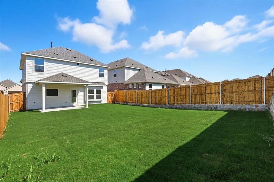 Rear view of house with a fenced backyard, a patio area, and a shingled roof Rear view of house with a fenced backyard, a patio area, and a shingled roof