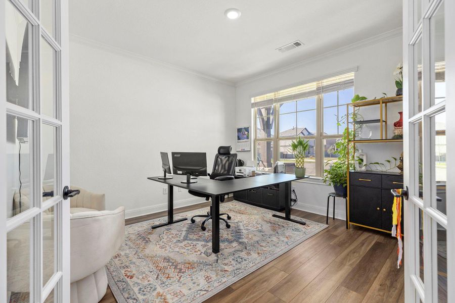 Home office featuring ornamental molding, dark wood finished floors, and french doors